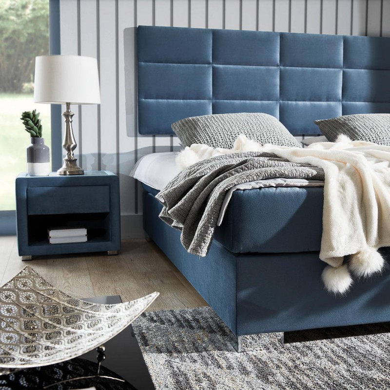 Łoże kontynentalne  z wezgłowiem wieszanym na ścianie pikowanym w foremne prostokąty. Ekonomiczne wymiarowo, nie zajmuje dodatkowego miejsca. Praktyczny pojemnik na stelażu elastycznym. Metalowa noga chromowana.