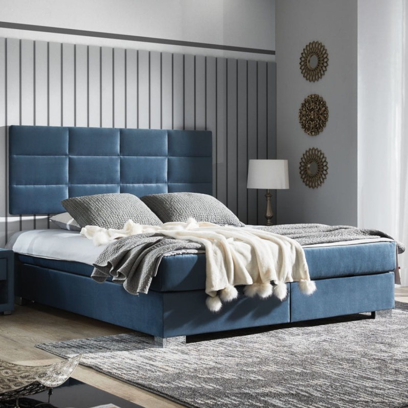 Łoże kontynentalne  z wezgłowiem wieszanym na ścianie pikowanym w foremne prostokąty. Ekonomiczne wymiarowo, nie zajmuje dodatkowego miejsca. Praktyczny pojemnik na stelażu elastycznym. Metalowa noga chromowana.